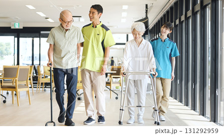 高齢者の歩行サポートをするアジア人介護士 131292959