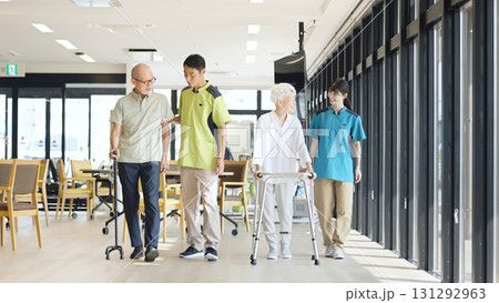 高齢者の歩行サポートをするアジア人介護士 131292963