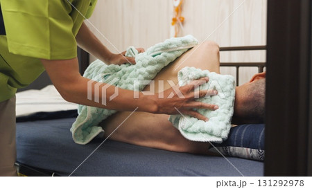 高齢者の清拭を行うアジア人介護士 131292978