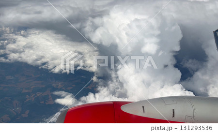 Wing of an airplane above white fluffy clouds in the blue sky. Wing of an airplane above white fluffy clouds in the blue sky. 131293536
