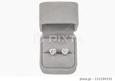 A pair of heart shaped diamond earrings are displayed in a gray box 131294332