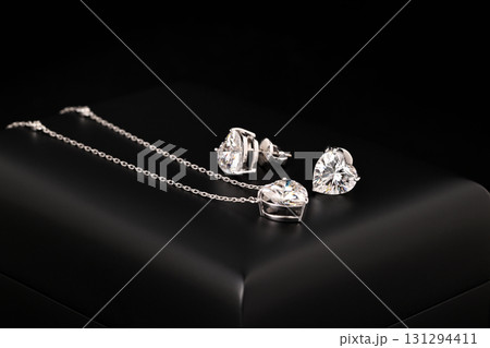 A heart shaped pendant with a chain is displayed in a black box 131294411