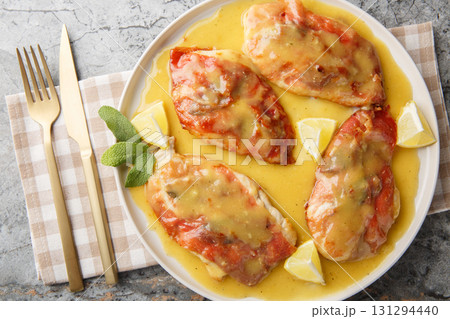 one pan chicken saltimbocca features prosciutto-draped chicken, crisp sage, and a lemony white wine sauce closeup on the plate. Horizontal top view one pan chicken saltimbocca features prosciutto-draped chicken, crisp sage, and a lemony white wine sauce closeup on the plate. Horizontal top view 131294440