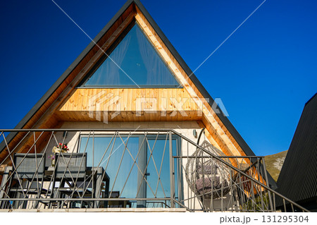 Wooden A-frame cabin in the Durmitor mountains, surrounded by forest and alpine landscape. Medium shot capturing the rustic charm and natural scenery Wooden A-frame cabin in the Durmitor mountains, surrounded by forest and alpine landscape. Medium shot capturing the rustic charm and natural scenery 131295304