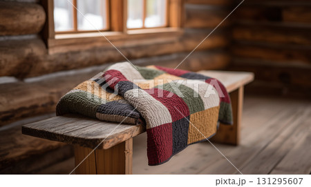 Cozy patchwork quilt on rustic wooden bench inside cabin interior Cozy patchwork quilt on rustic wooden bench inside cabin interior 131295607