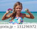 Happy Child Displaying Colorfully Painted Stones at the Beach 131296972