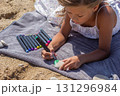 Kid drawing on a flat stone using bright markers 131296984