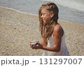 Young child picking up rocks 131297007