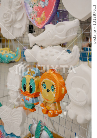 Unpainted plaster toys on the counter: owl, teddy bear, fish and other figurines Unpainted plaster toys on the counter: owl, teddy bear, fish and other figurines 131297613