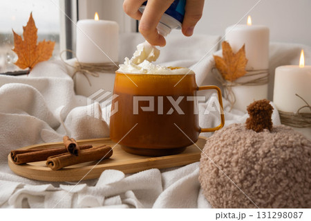 Seasonal drink cacao coffee with whipped cream and cinnamon sticks Thanksgiving and Hello Fall Halloween concept. Celebrating autumn holidays at cozy home on the windowsill atmosphere Autumn leaves 131298087