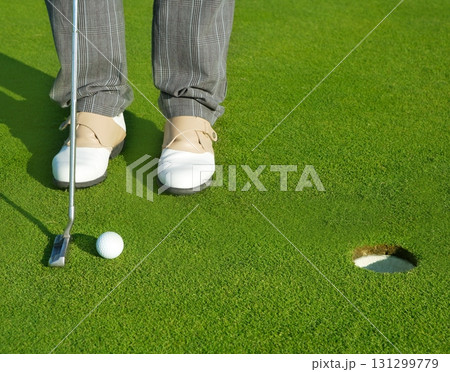 Golf green hole course man putting short ball Golf green hole course man putting short ball 131299779