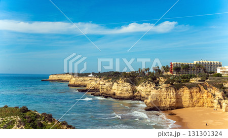 Stunning image of Algarve iconic cliffs of Seven Hanging Valleys and golden sandy beach. Serene shoreline, set against the clear blue ocean, capturing Portugal natural beauty 131301324