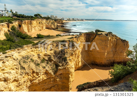 Stunning image of Algarve iconic cliffs of Seven Hanging Valleys and golden sandy beach. Serene shoreline, set against the clear blue ocean, capturing Portugal natural beauty 131301325