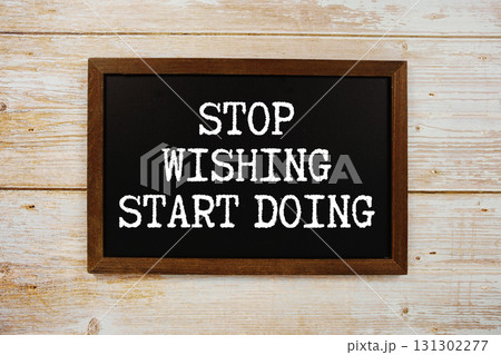 Stop Wishing Start Doing text written on blackboard flat lay on wooden background 131302277