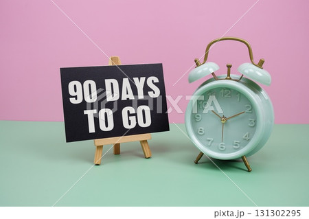 90 Days To Go text with alarm clock on pink and green background 90 Days To Go text with alarm clock on pink and green background 131302295