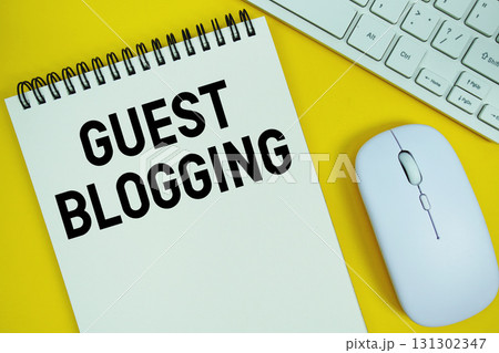 Notepad with the text "Guest Blogging" with white keyboard and wireless mouse on yellow background Notepad with the text "Guest Blogging" with white keyboard and wireless mouse on yellow background 131302347