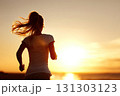 Silhouette of a young woman running on the beach during sunset. The vibrant hues of sunset create a magical atmosphere as the silhouette of a young woman runs along the shoreline. 131303123