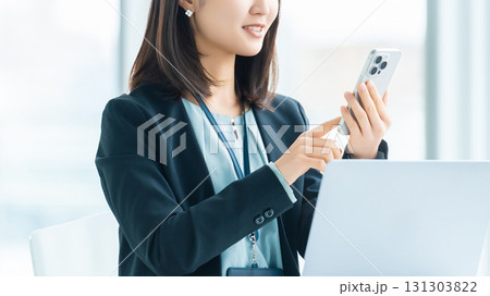 スマートフォンを使う笑顔の女性・ビジネスウーマン スマートフォンを使う笑顔の女性・ビジネスウーマン 131303822