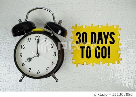 30 Days To Go! text with alarm clock on yellow background 131303880