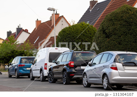 City street single-family modern houses Germany against warm sunset sky. German suburban small town residential area row eco sustainable life building neighborhood suburb. Urban car parking driveway City street single-family modern houses Germany against warm sunset sky. German suburban small town residential area row eco sustainable life building neighborhood suburb. Urban car parking driveway 131304107