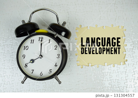 Language Development text with alarm clock on yellow background Language Development text with alarm clock on yellow background 131304557
