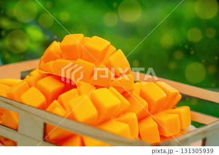 Cutted artificial fruits of orange ripe mango. There are multi-colored bokeh effect elements around the edges of the frame. Imitation of food, crop time, harvesting concept Cutted artificial fruits of orange ripe mango. There are multi-colored bokeh effect elements around the edges of the frame. Imitation of food, crop time, harvesting concept 131305939