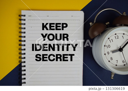 Keep Your Identity Secret text written on notepad with alarm clock on yellow background Keep Your Identity Secret text written on notepad with alarm clock on yellow background 131306619