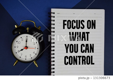 Focus on What You Can Control text written on notepad with alarm clock on blue background Focus on What You Can Control text written on notepad with alarm clock on blue background 131306673