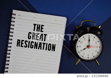 The Great Resignation text written on notepad with alarm clock on blue background 131306680