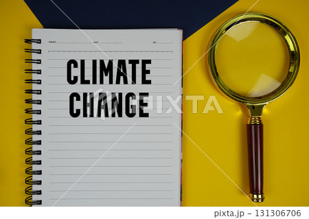 Climate Change text with magnifying glass on yellow background 131306706
