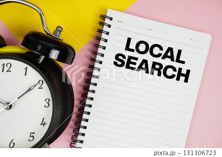 Local Search text written on notepad with alarm clock on pink background Local Search text written on notepad with alarm clock on pink background 131306723