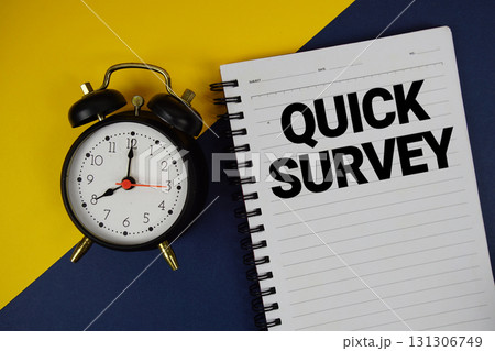 Quick Survey text written on notepad with alarm clock on blue background 131306749