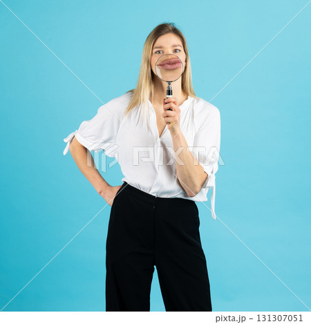 Studio portrait of woman with magnifying glass 131307051