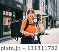 配達する笑顔の女性デリバリースタッフ：街のフードサービス 131311782