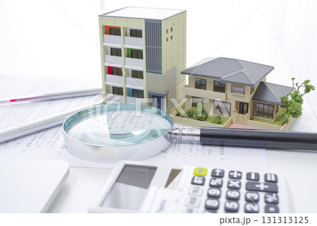 資産価値を確認する不動産の模型と虫眼鏡 131313125