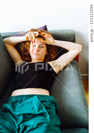 young red-haired woman tired lies on sofa young red-haired woman tired lies on sofa 131313594