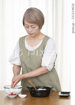 キッチンでおにぎりを握るシニア女性 131314618