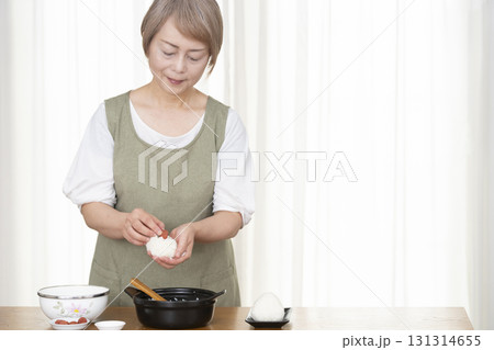 キッチンでおにぎりを握るシニア女性 キッチンでおにぎりを握るシニア女性 131314655
