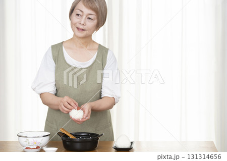 キッチンでおにぎりを握るシニア女性 131314656