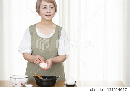 キッチンでおにぎりを握るシニア女性 131314657
