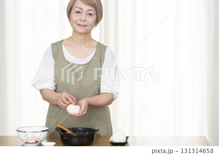 キッチンでおにぎりを握るシニア女性 131314658