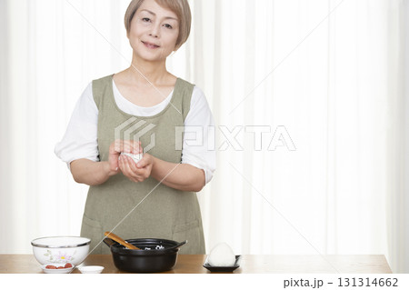 キッチンでおにぎりを握るシニア女性 131314662