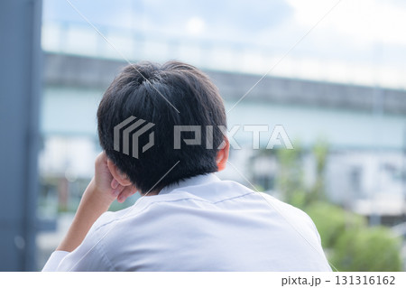空を見上げる受験や未来や進路について考える少年 131316162