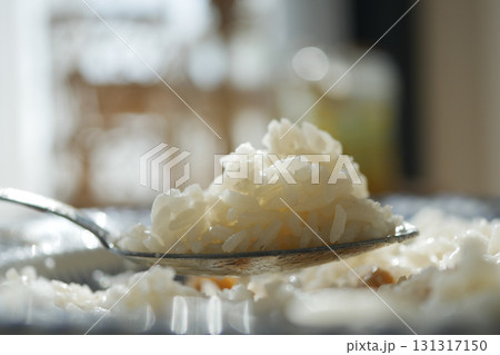 Delicious white rice served on a spoon in bright sunlight 131317150