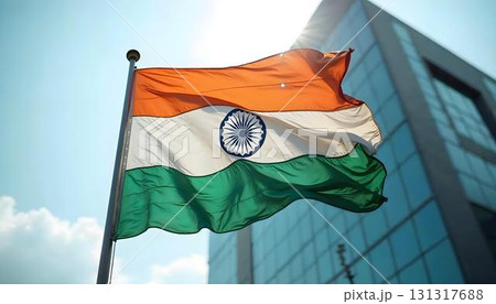 The Indian flag billows in front of a building, commemorating Independence Day with a celebratory background 131317688