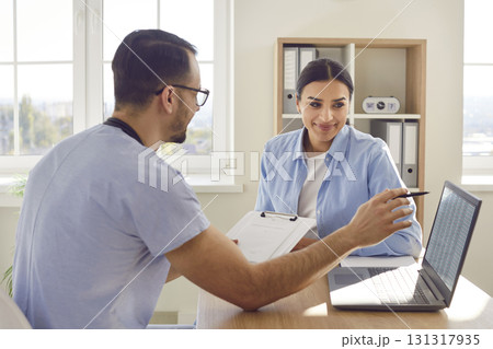 Medical consultation with male doctor in clinic, female patient visit Medical consultation with male doctor in clinic, female patient visit 131317935