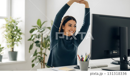 Woman Stretching at Her Desk During Work Break Woman Stretching at Her Desk During Work Break 131318336
