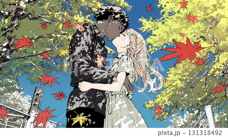 秋の紅葉の下でキスをしている若い恋人たち