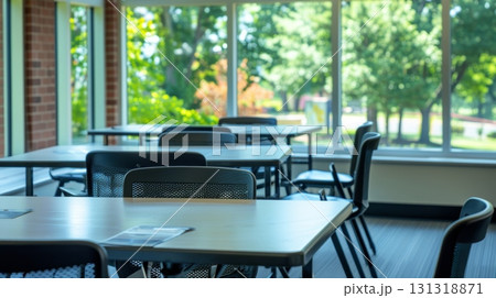 Empty tables and chairs in a bright room facing a green park 131318871