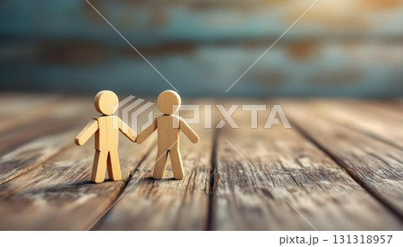 Handcrafted wooden couple holding hands on a table, evoking themes of family and friendship in a rustic background Handcrafted wooden couple holding hands on a table, evoking themes of family and friendship in a rustic background 131318957
